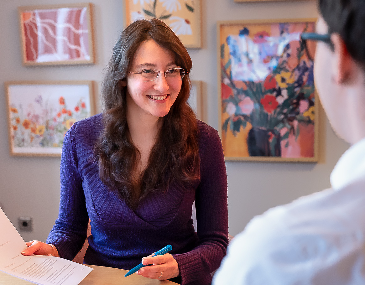 Vier junge Menschen, die an einem Tisch gemeinsam arbeiten, während sich zwei von ihnen begeistert ein High Five geben