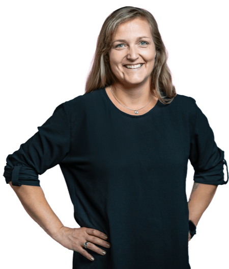 Caroline Brinkmann hat die Arme in der Hüfte und lächelt in die Kamera