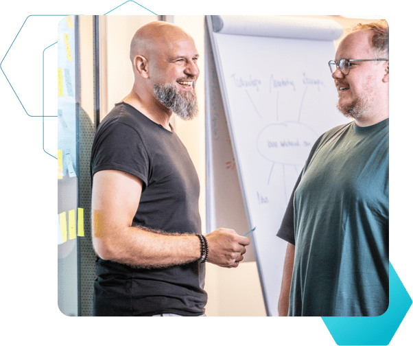 Zwei Männer arbeiten fröhlich zusammen und haben eine Mindmap auf einem Whiteboard abgebildet